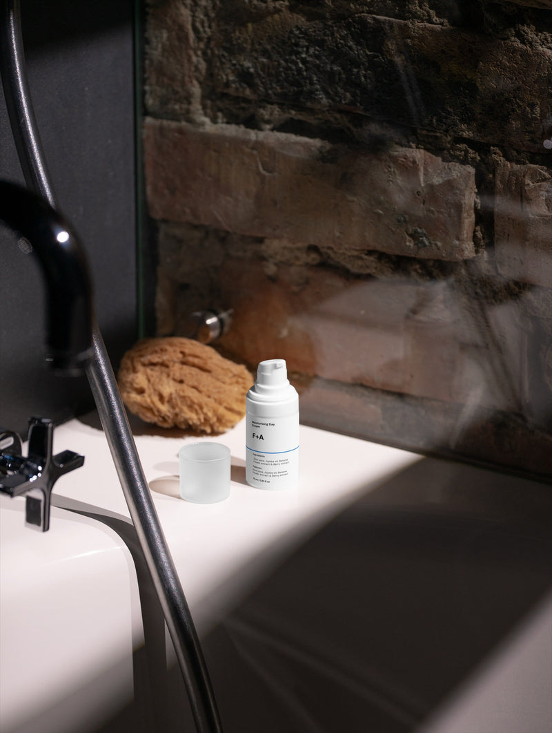 F+A face moisturiser sitting on the side of a bathtub